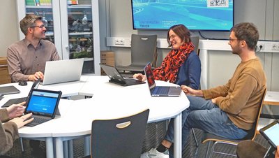 [Translate to Englisch:] 4 Personen sitzen mit Laptops am Tisch